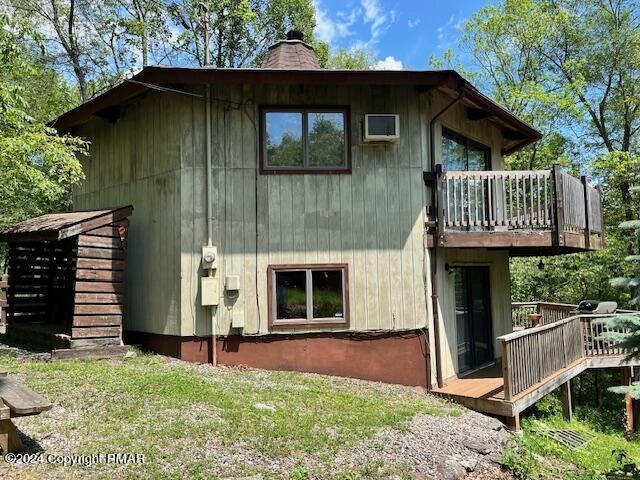 rear view of house featuring a chimney and a deck