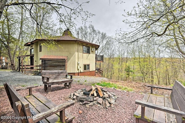 view of property exterior featuring a fire pit and a chimney