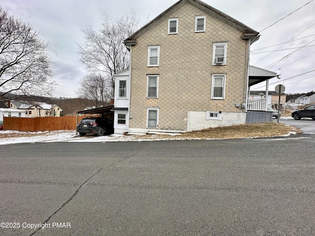 view of side of property featuring a carport and fence