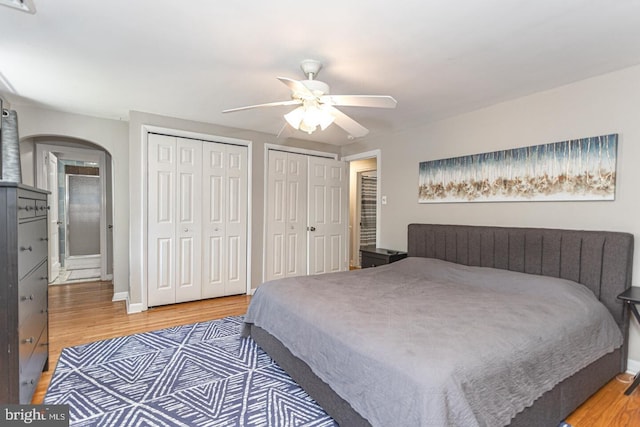 104 Lowrys Ln, Bryn Mawr, PA 19010 - bedroom featuring two closets, arched walkways, light wood-style flooring, and ceiling fan
