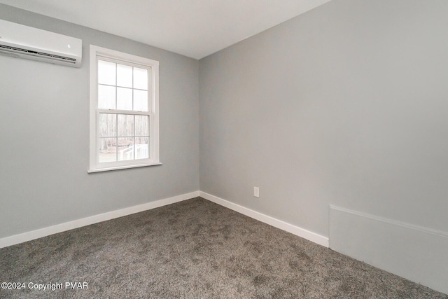 unfurnished room featuring dark colored carpet, a wall mounted air conditioner, and baseboards