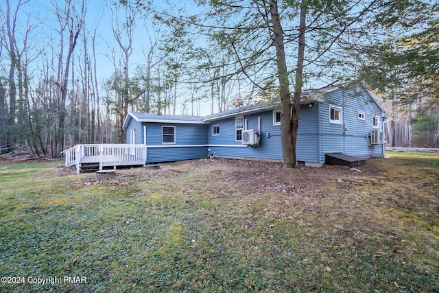 view of front of property featuring a deck, a front lawn, and cooling unit