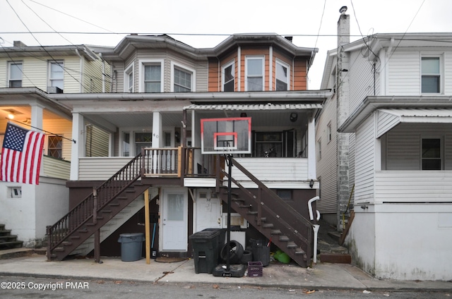 townhome / multi-family property featuring a porch and stairway