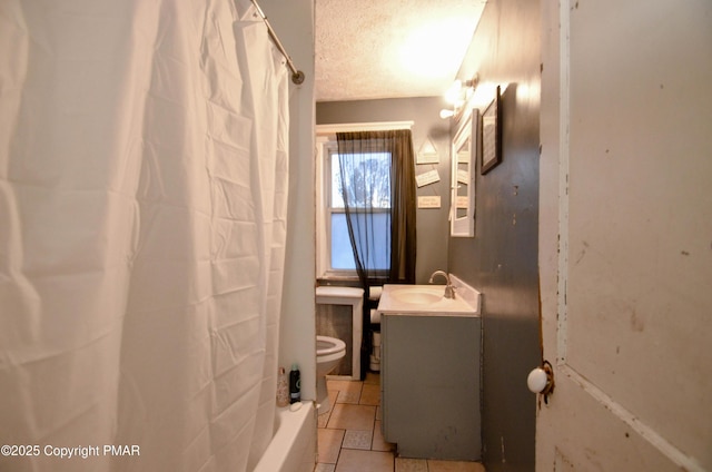 bathroom with vanity, toilet, and a textured ceiling