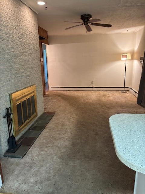 unfurnished living room featuring carpet flooring, a ceiling fan, and a fireplace
