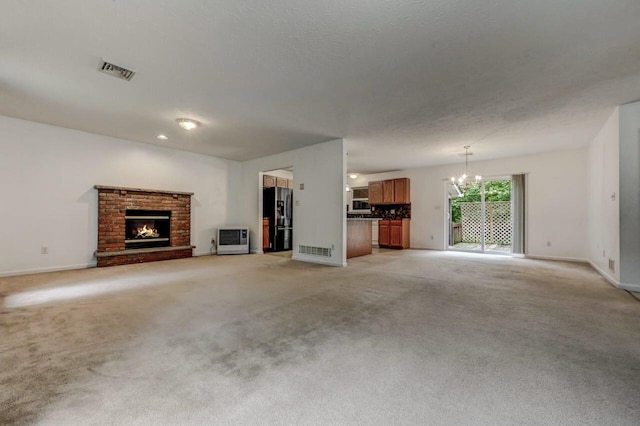 1162 Colt Ln, Pocono Summit, PA 18346 - unfurnished living room with a chandelier, a brick fireplace, heating unit, and light carpet