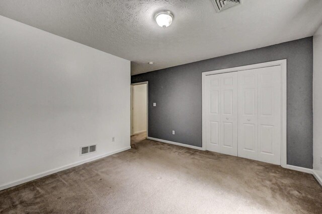 1162 Colt Ln, Pocono Summit, PA 18346 - unfurnished bedroom featuring carpet, a closet, and a textured ceiling