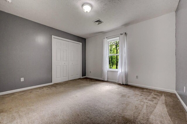 1162 Colt Ln, Pocono Summit, PA 18346 - unfurnished bedroom with carpet floors, a textured ceiling, and a closet
