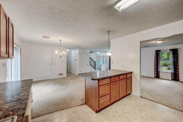 1162 Colt Ln, Pocono Summit, PA 18346 - kitchen with dark countertops, light colored carpet, open floor plan, a peninsula, and brown cabinetry