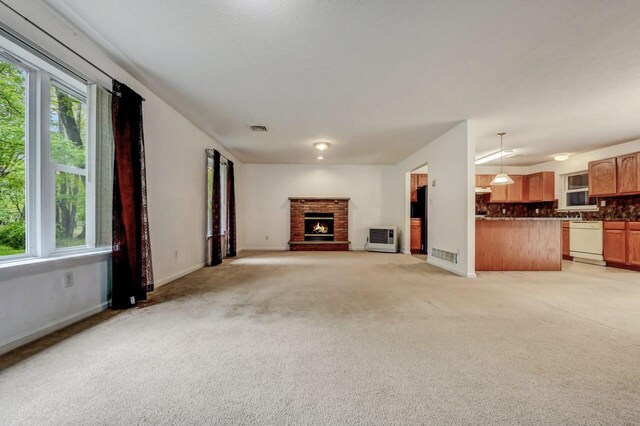 1162 Colt Ln, Pocono Summit, PA 18346 - unfurnished living room featuring a brick fireplace, light carpet, and heating unit