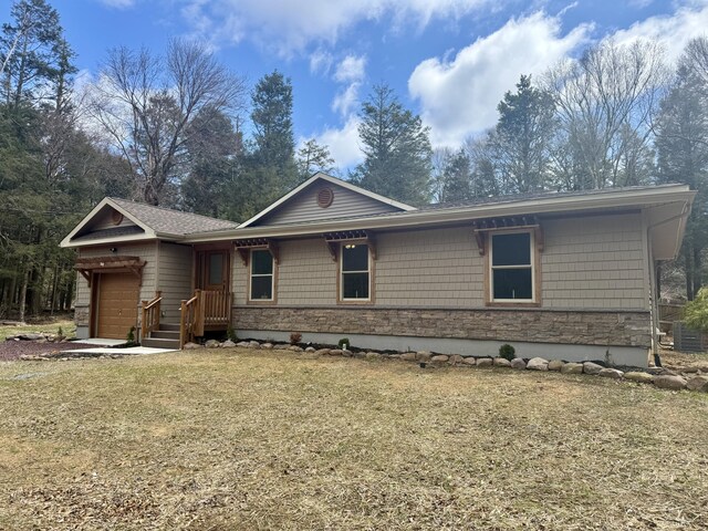 52 Tanglewood Dr, Albrightsville, PA 18210 - view of front of property featuring an attached garage, stone siding, and a front lawn