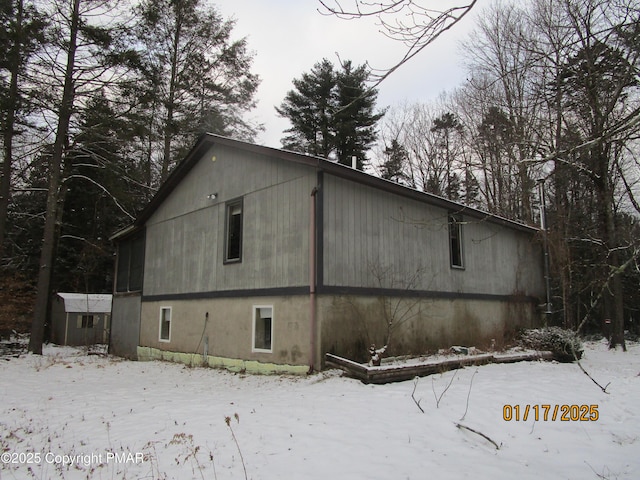 snow covered property with an outdoor structure