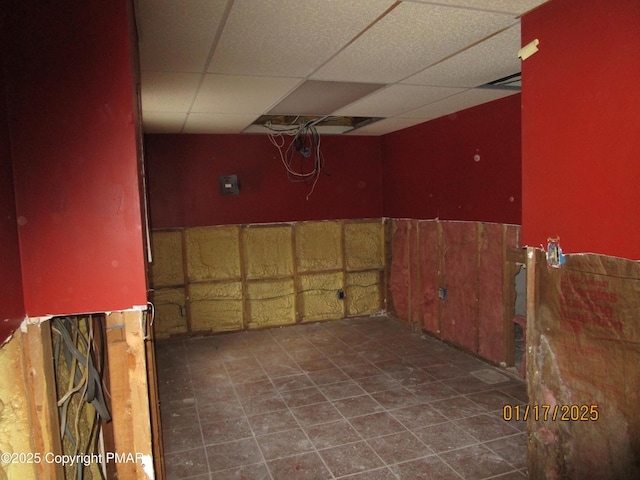 interior space featuring tile patterned flooring and a drop ceiling