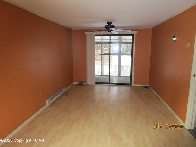 unfurnished room with a baseboard heating unit, light wood-type flooring, ornamental molding, and baseboards