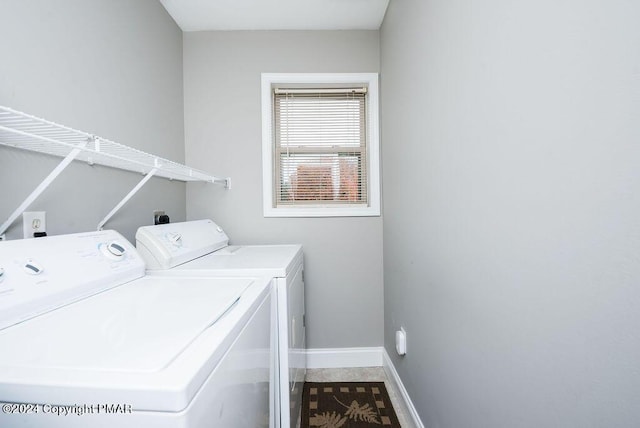 washroom featuring laundry area, baseboards, and washer and dryer