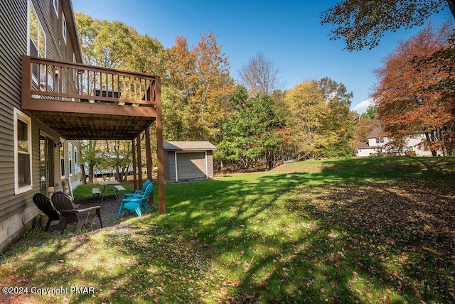 view of yard featuring a storage shed, a deck, and an outbuilding