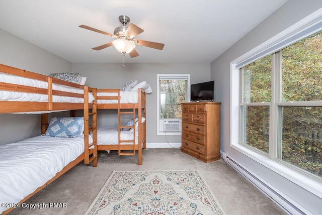 carpeted bedroom featuring a baseboard heating unit, ceiling fan, and baseboards