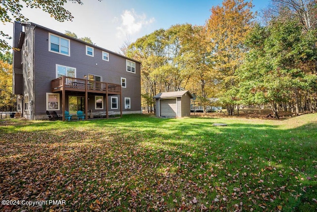 back of property with a yard, an outdoor structure, a deck, and a storage unit