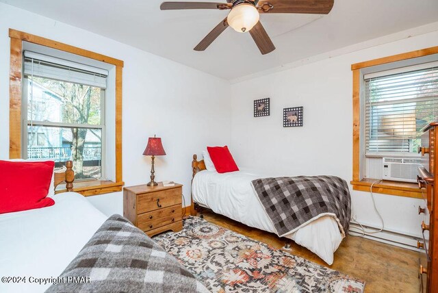 bedroom with ceiling fan, baseboard heating, and cooling unit