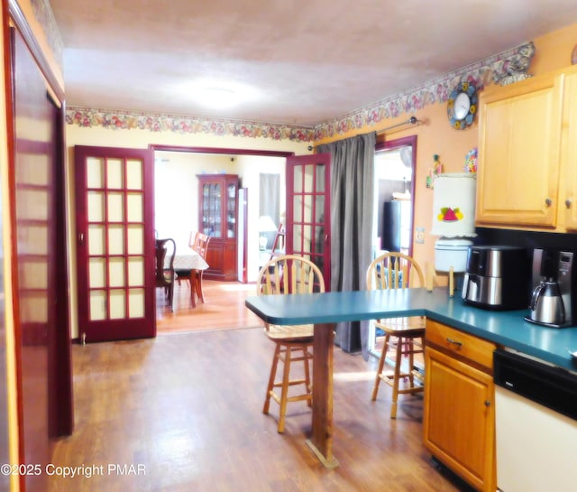 kitchen with french doors, wood finished floors, and white dishwasher