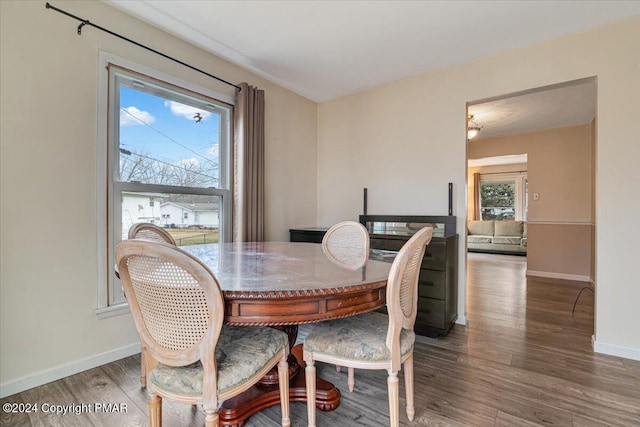 dining area with baseboards and wood finished floors