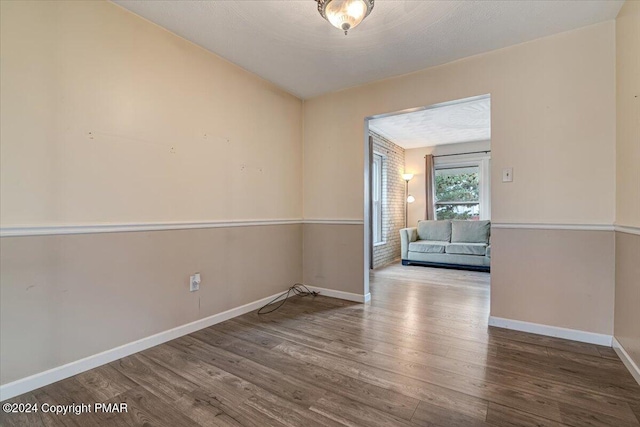 spare room featuring baseboards and wood finished floors