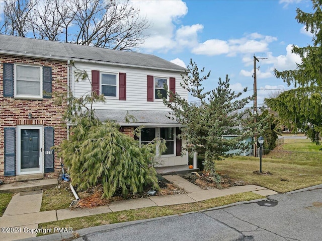 view of front of home featuring a front lawn and brick siding