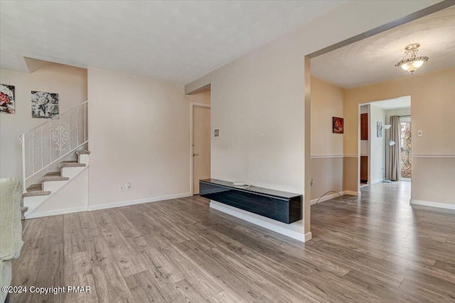 interior space featuring stairway, wood finished floors, and baseboards