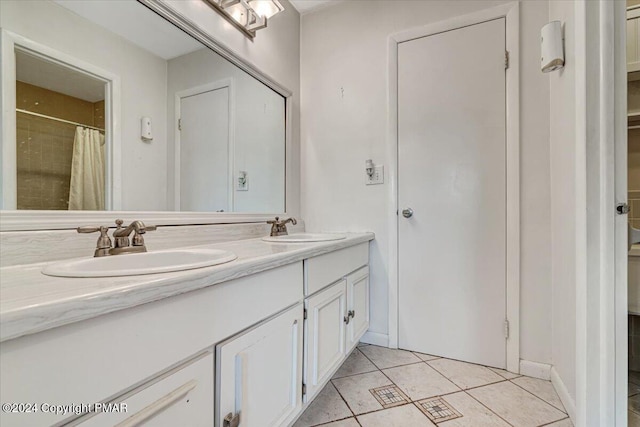 bathroom featuring a sink, double vanity, a closet, and tile patterned flooring