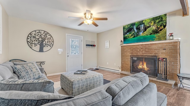 9148 Brandywine Dr, Tobyhanna, PA 18466 - living room with baseboard heating, a ceiling fan, light wood-style flooring, and a brick fireplace