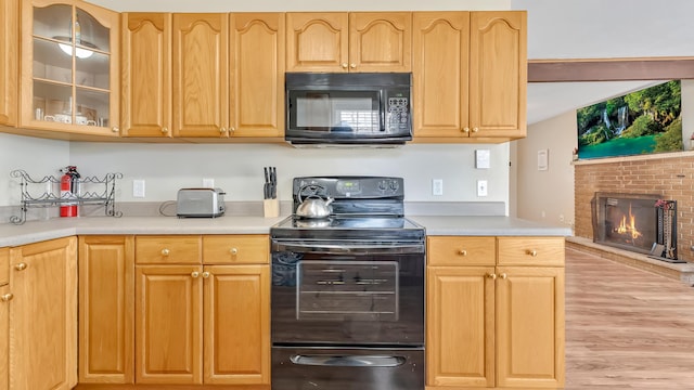 9148 Brandywine Dr, Tobyhanna, PA 18466 - kitchen featuring black appliances, light countertops, glass insert cabinets, and light wood finished floors