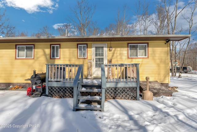 snow covered property with a deck