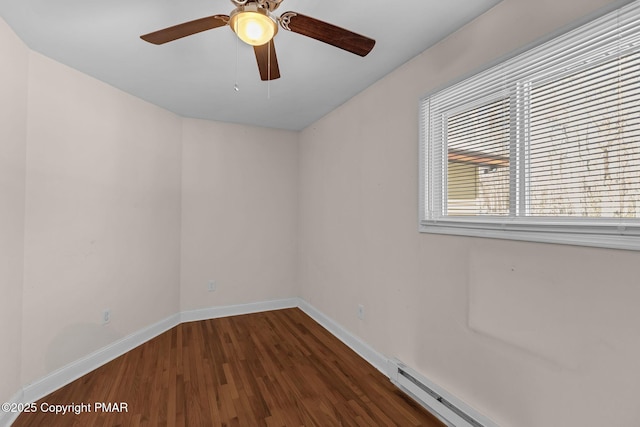 unfurnished room featuring a baseboard heating unit, a ceiling fan, baseboards, and wood finished floors