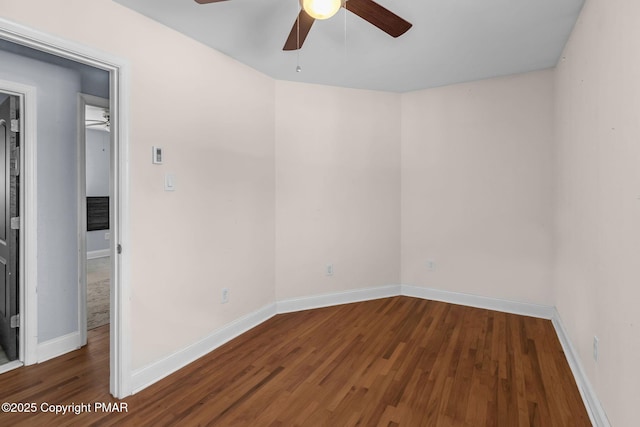 spare room with a ceiling fan, baseboards, and wood finished floors