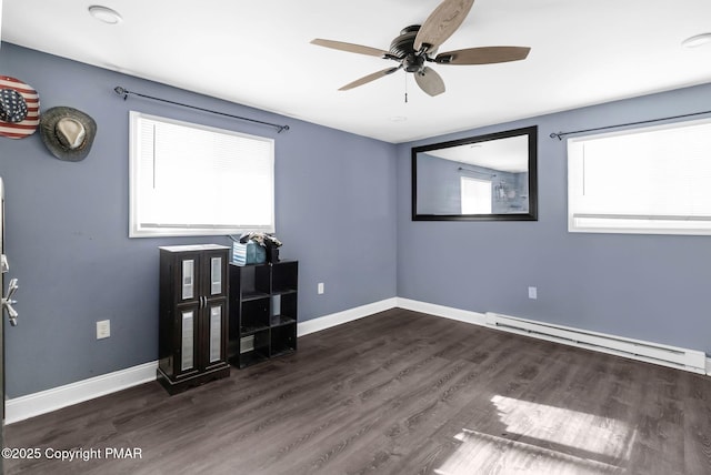 empty room with a ceiling fan, baseboards, baseboard heating, and wood finished floors