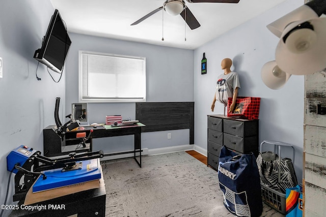 office space featuring a baseboard heating unit, ceiling fan, and baseboards