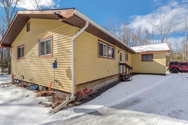 snow covered property featuring entry steps