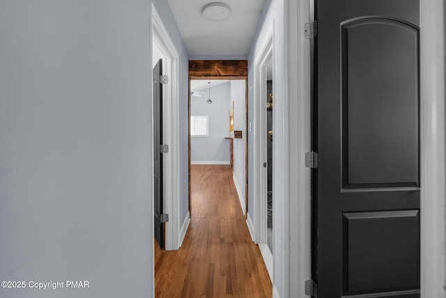 hallway with wood finished floors and baseboards