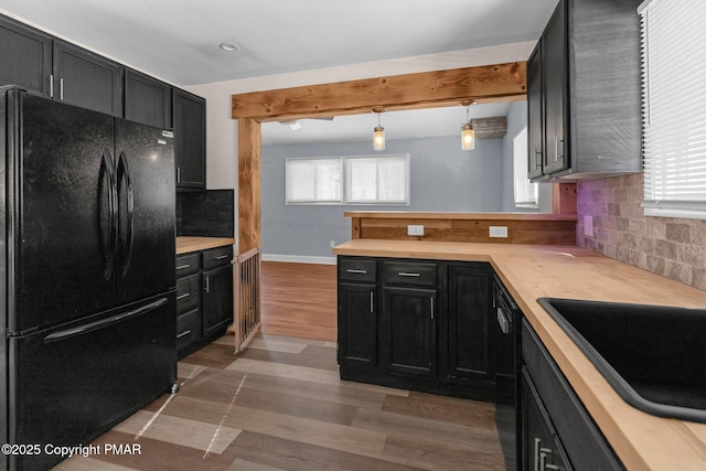 kitchen with sink, decorative light fixtures, black appliances, a wealth of natural light, and backsplash