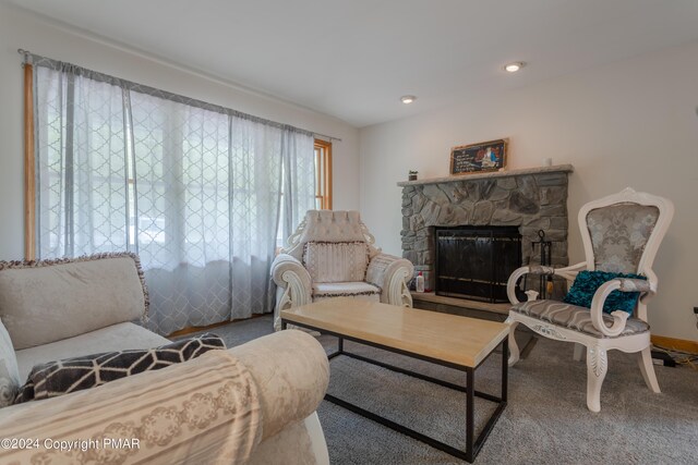 carpeted living room with recessed lighting, a stone fireplace, and baseboards