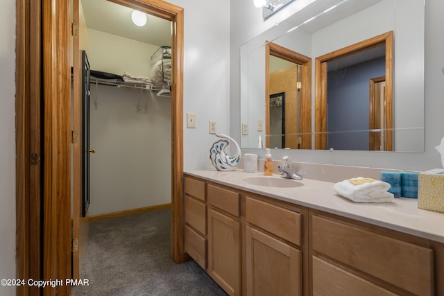 bathroom with a spacious closet and vanity