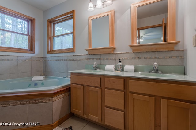 bathroom featuring tile patterned flooring, a sink, a bath, and double vanity