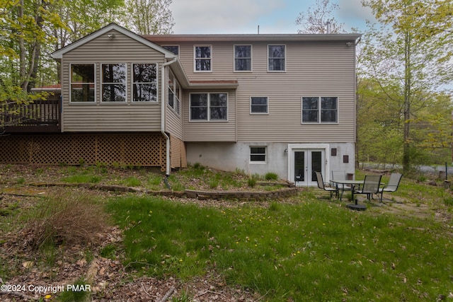 back of house featuring a yard and french doors