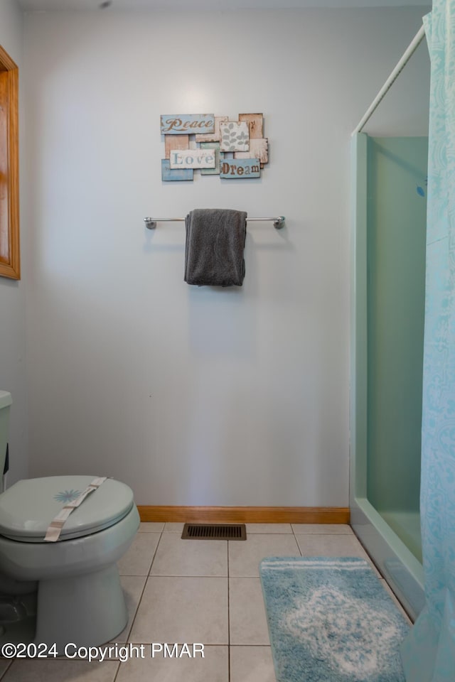 bathroom featuring toilet, curtained shower, visible vents, and tile patterned floors