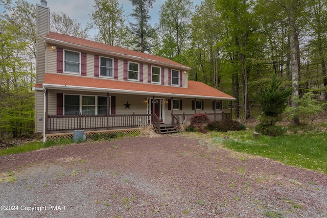 view of front of house with covered porch and a chimney