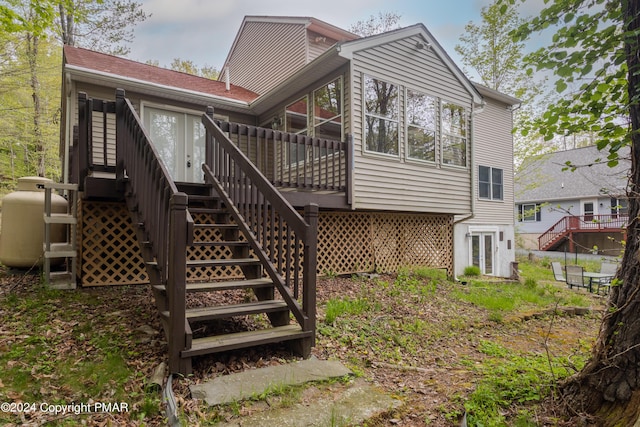 back of house featuring a wooden deck and stairs