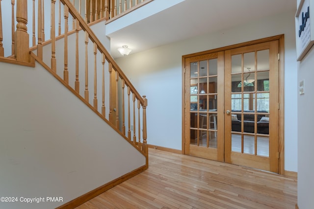 interior space with french doors, baseboards, and wood finished floors