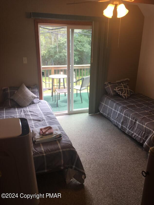 carpeted bedroom with access to exterior and a ceiling fan