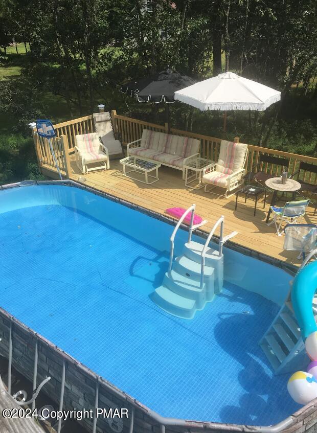 view of pool featuring a deck and outdoor lounge area