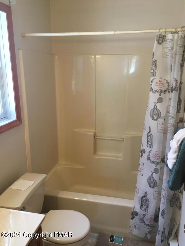 full bath with toilet, visible vents, shower / bath combo with shower curtain, and vanity